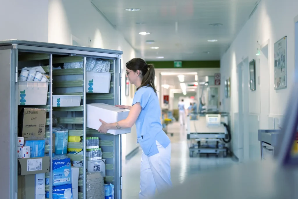 Eine Krankenschwester lädt medizinisches Material aus dem IML Trolley aus.