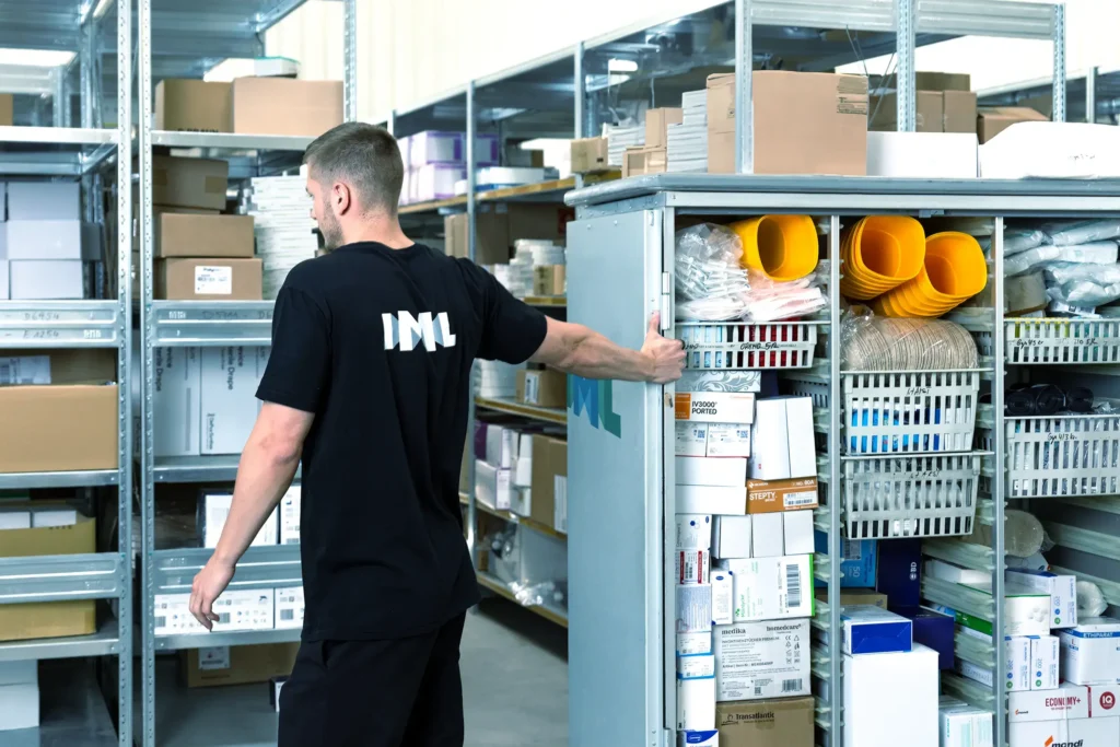 Ein IML Mitarbeiter zieht den voll gefüllten Trolley zum nächsten Regal.